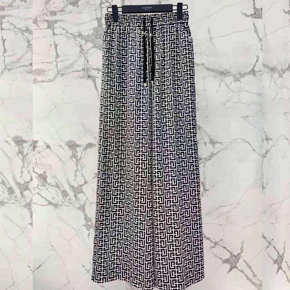 Close-up on monogram detailing and branded hardware on the trousers