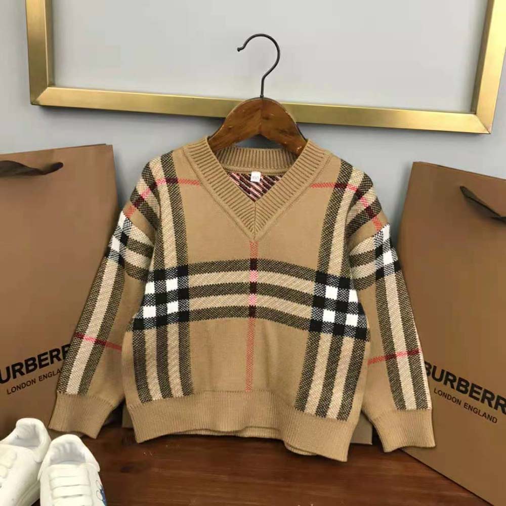 Side angle of beige Burberry Kids’ Check Wool Sweater with folded sleeves