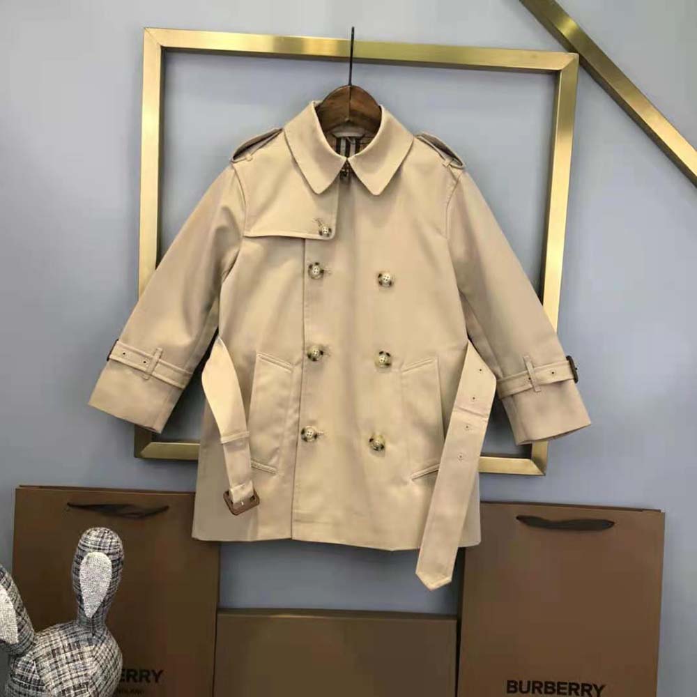 Side profile showing button closure and silhouette of Burberry Kids’ trench
