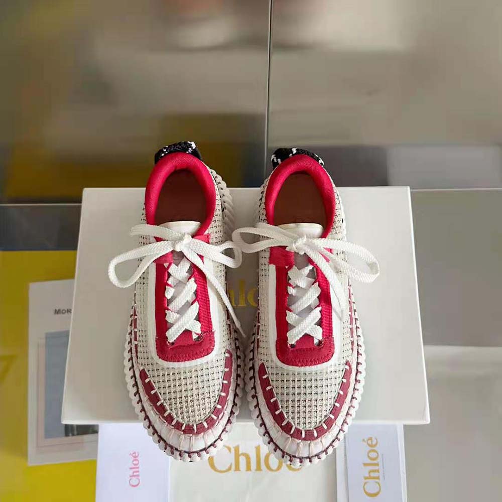 Close-up of embossed Chloé logo on red leather sneaker tongue