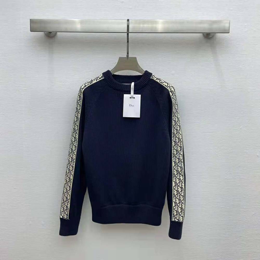 Close-up of Dior Oblique inserts on deep blue cotton jersey sweater