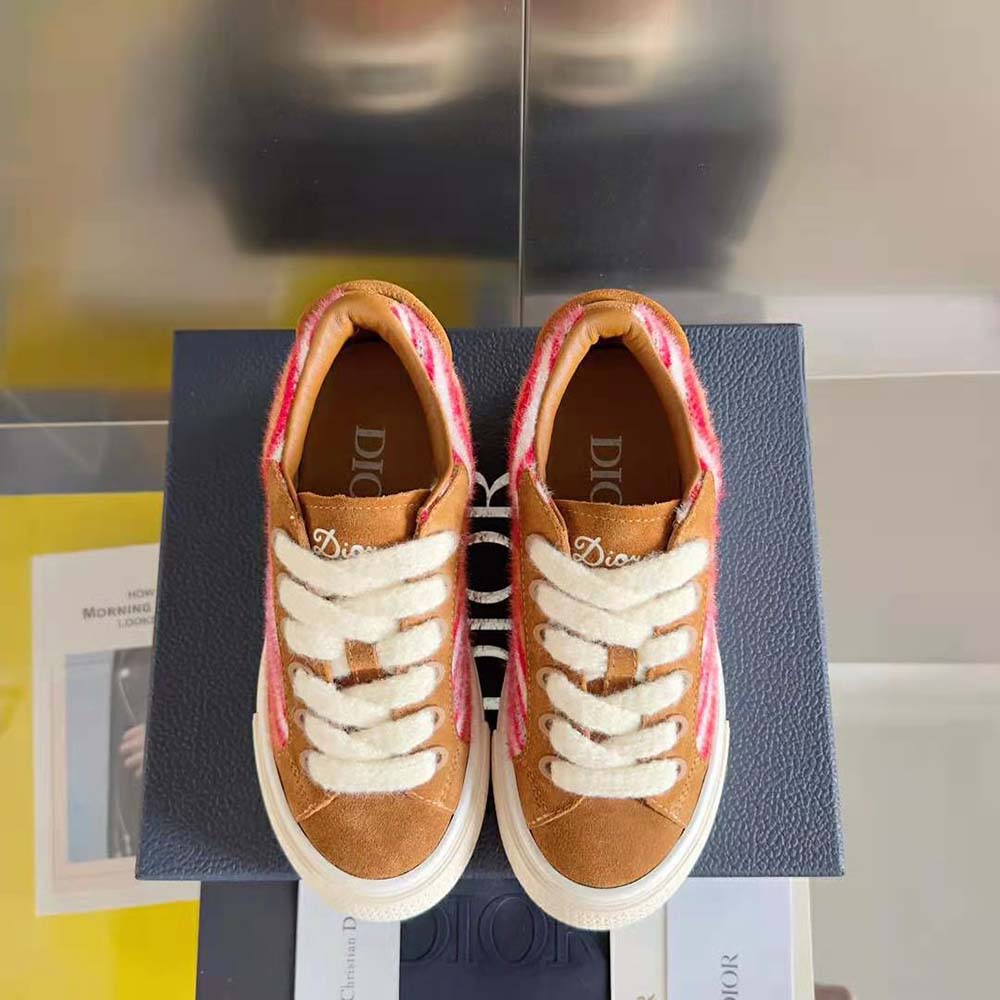 Close-up on signature tear detail and red leather of Dior Men Tears B33 Sneaker