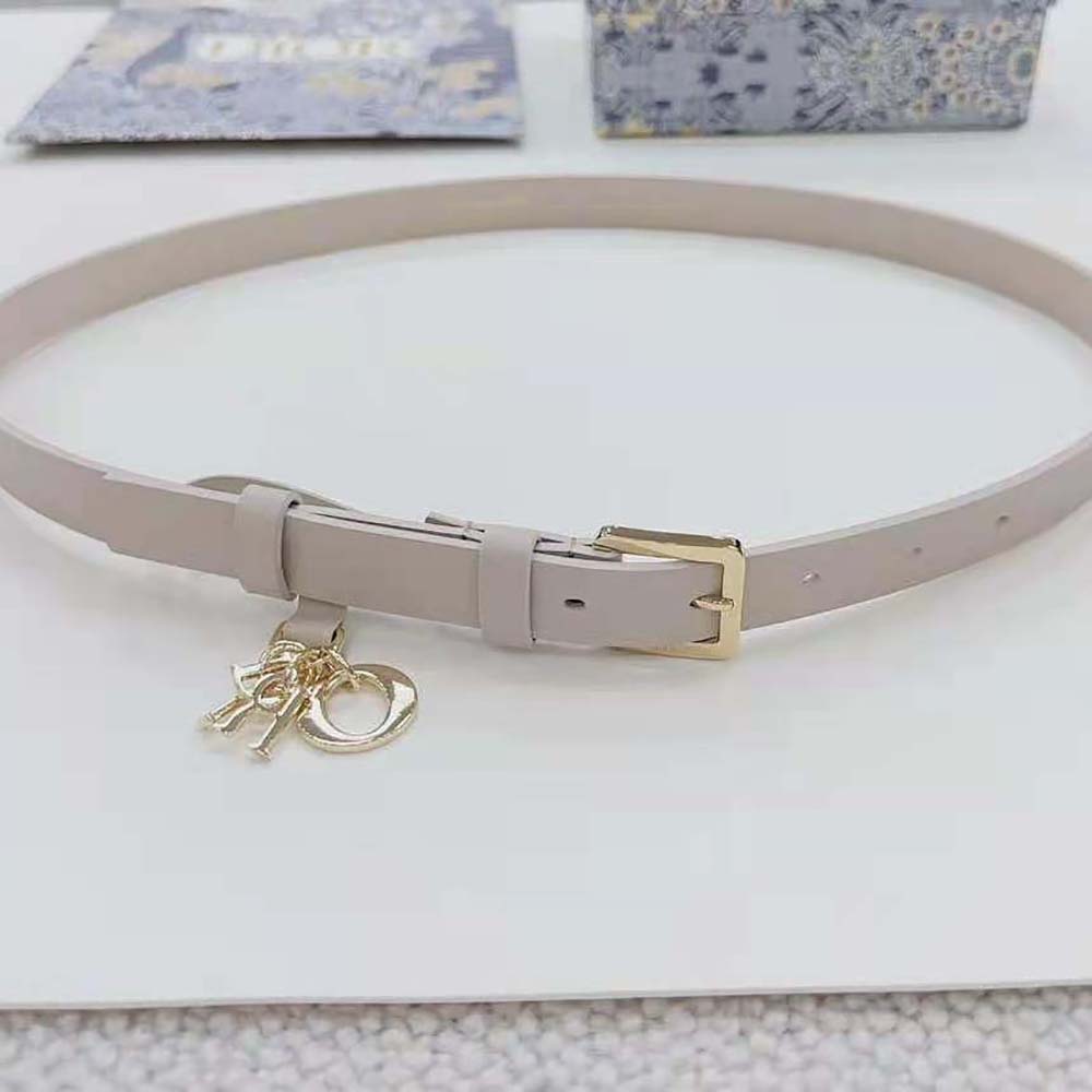 Close-up of Dior engraved metal hardware on white belt