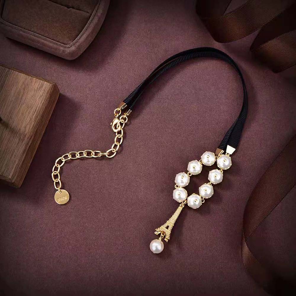 Side angle showing black grosgrain and gold-finish metal clasp on choker