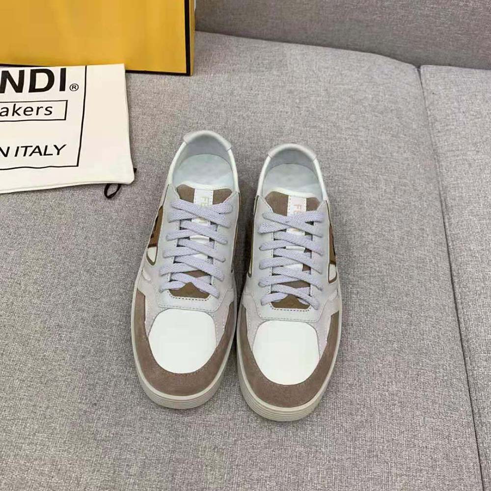 Close-up of smooth beige leather and Fendi branding on sneakers