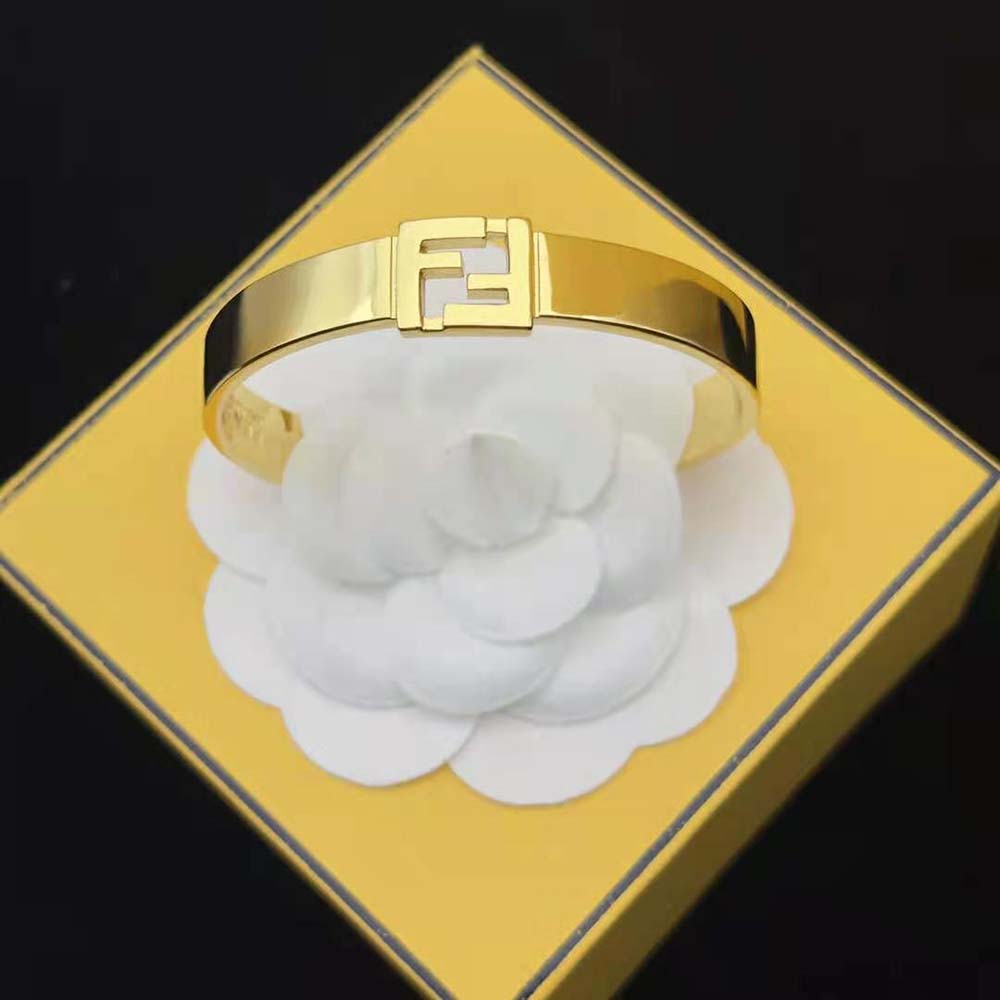 Angled view showcasing gold-colored metal and logo of Fendi bracelet