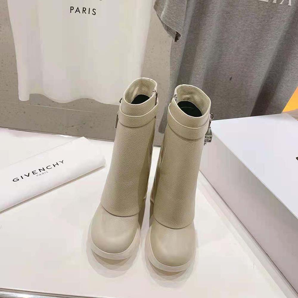 Close-up of Shark Lock hardware on beige Givenchy biker ankle boots