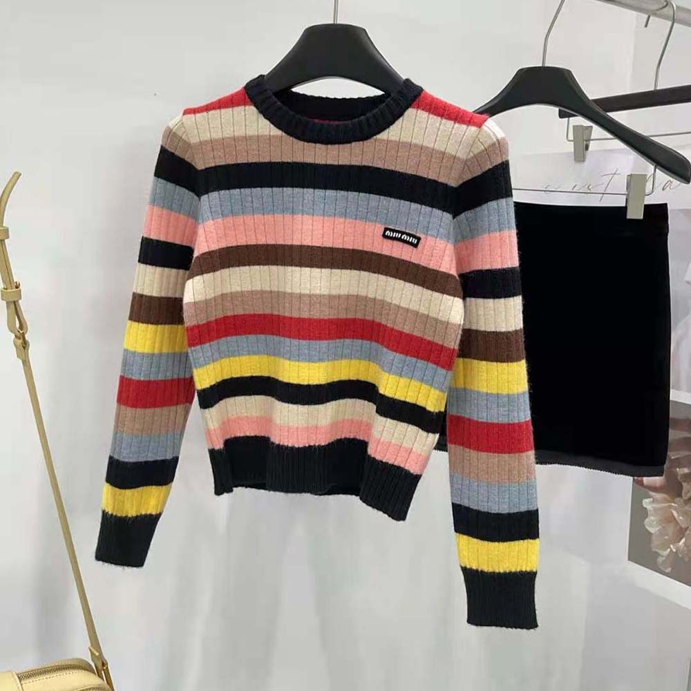 Close-up of Miu Miu logo patch on black cashmere sweater sleeve