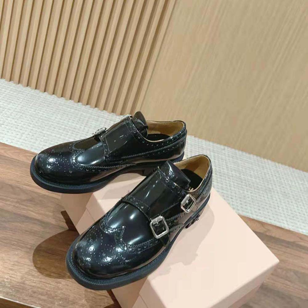 Top angle showing brogue perforation detail on black brushed leather shoes