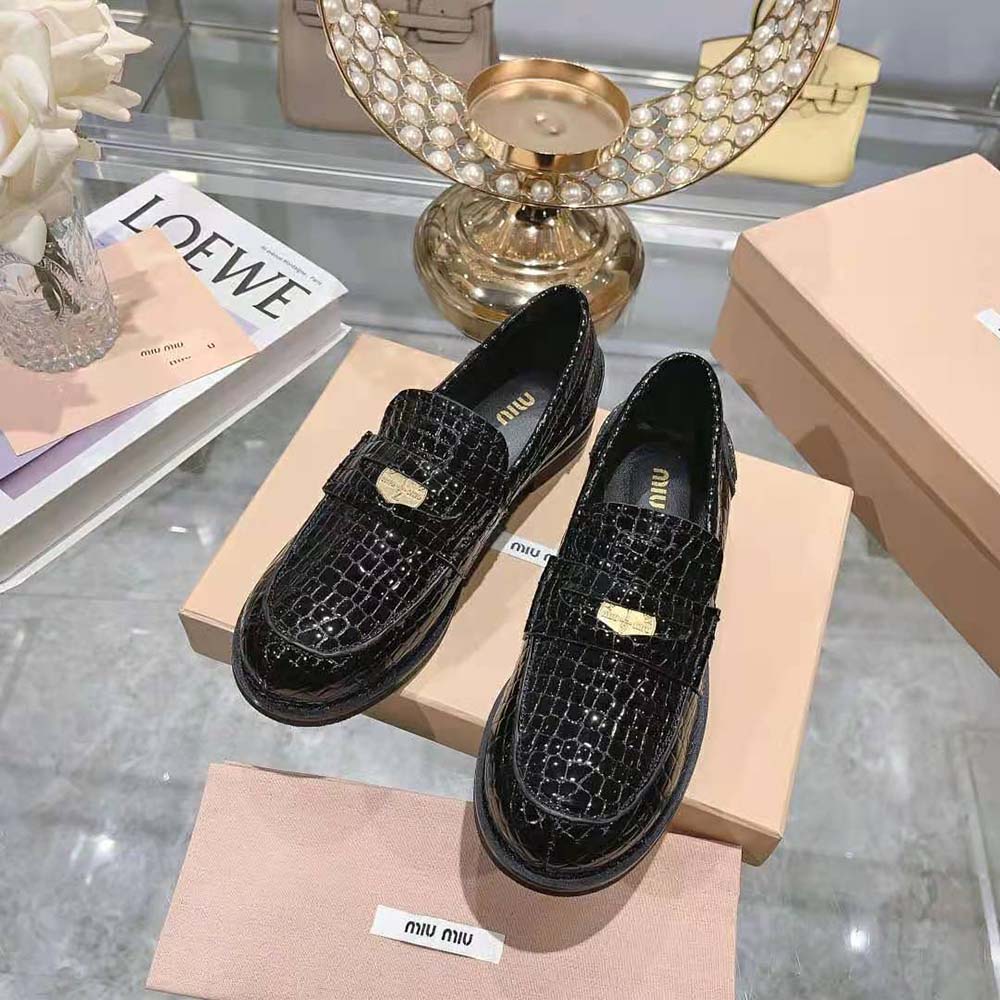 Top view of polished hardware and slip-on design on Miu Miu loafers
