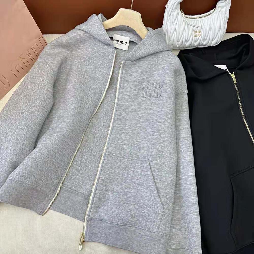 Close-up on embroidered logo detail on Miu Miu silver hoodie