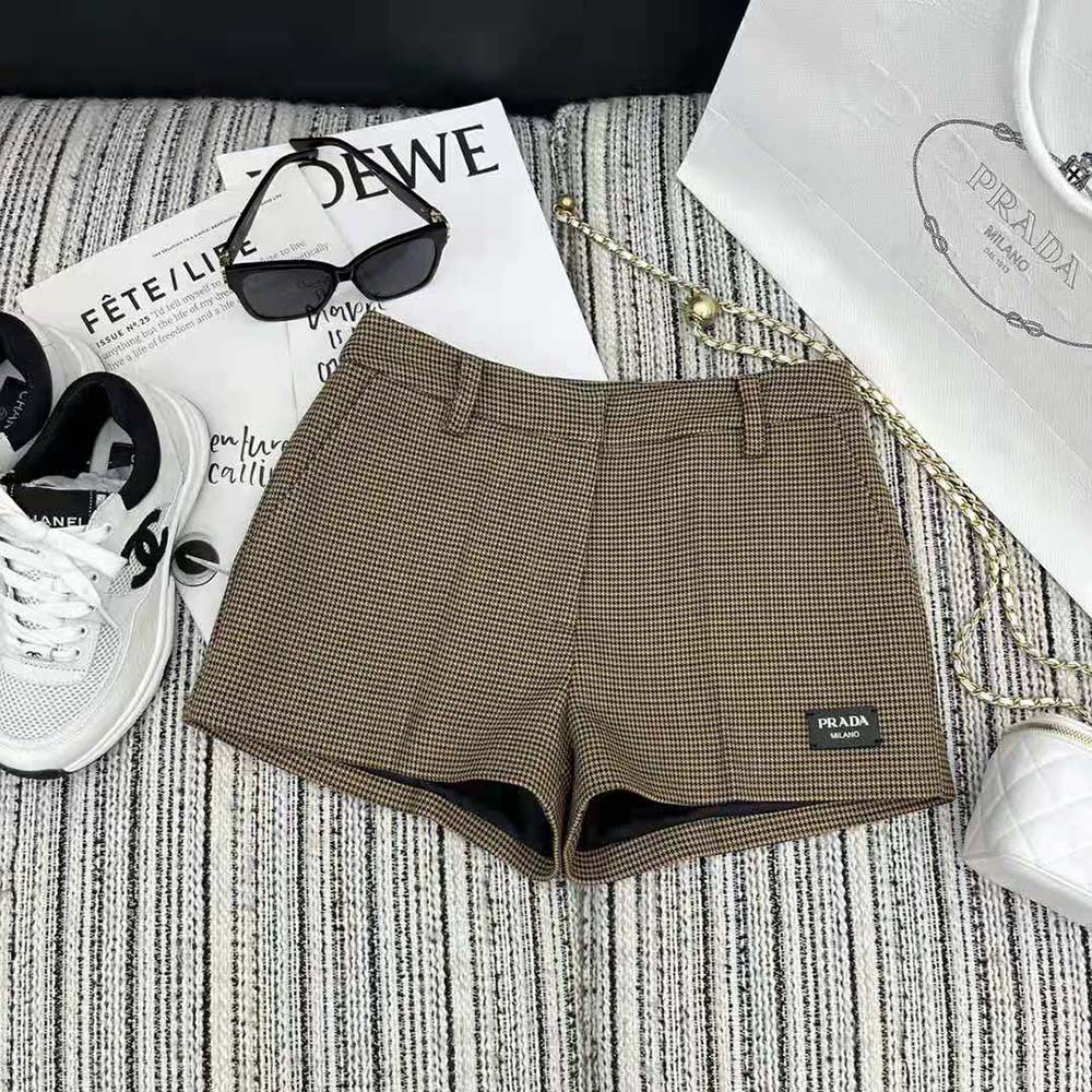 Close-up of houndstooth pattern and branded button on Prada shorts