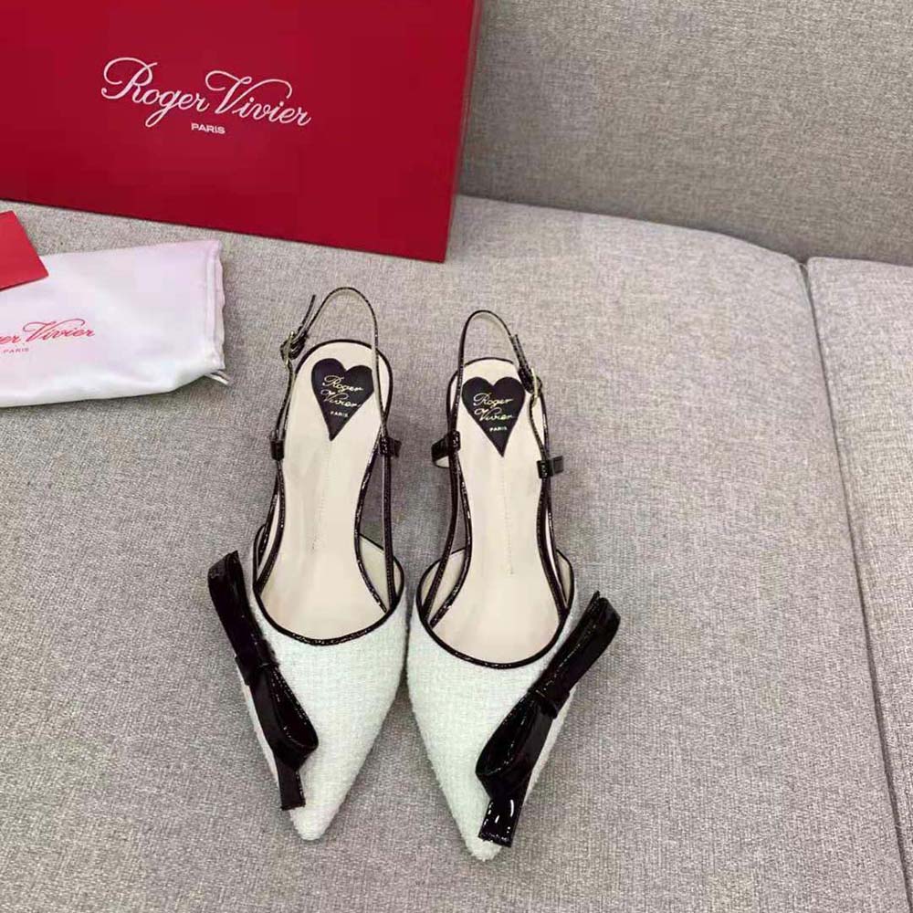 Close-up on signature Virgule bow detail of white fabric slingback pumps