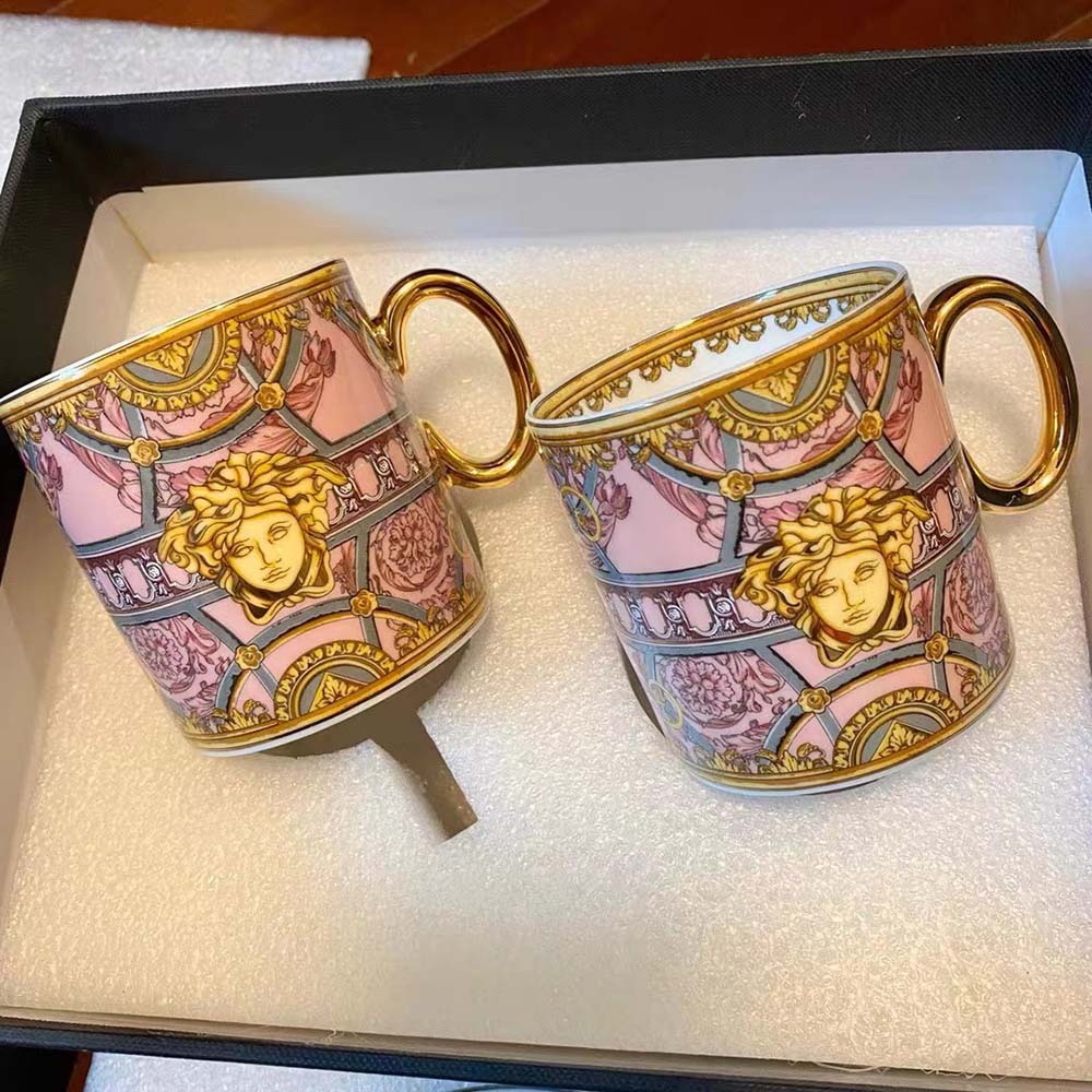 Close-up on gold Medusa emblem detail on Versace Scala Del Palazzo Verde Mug-Pink