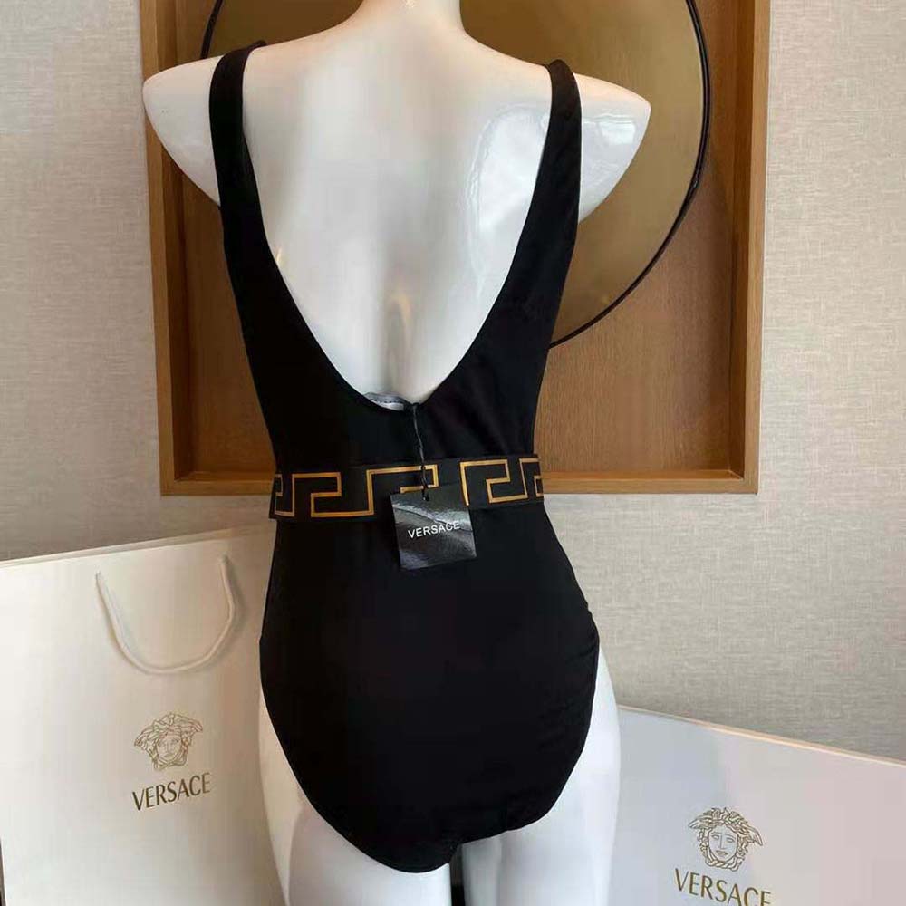 Back angle showing smooth black fabric and sleek silhouette of Versace swimsuit
