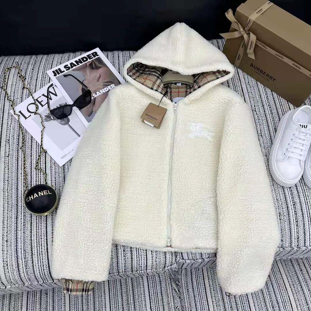 Close-up of Burberry logo hardware on white fleece hooded jacket