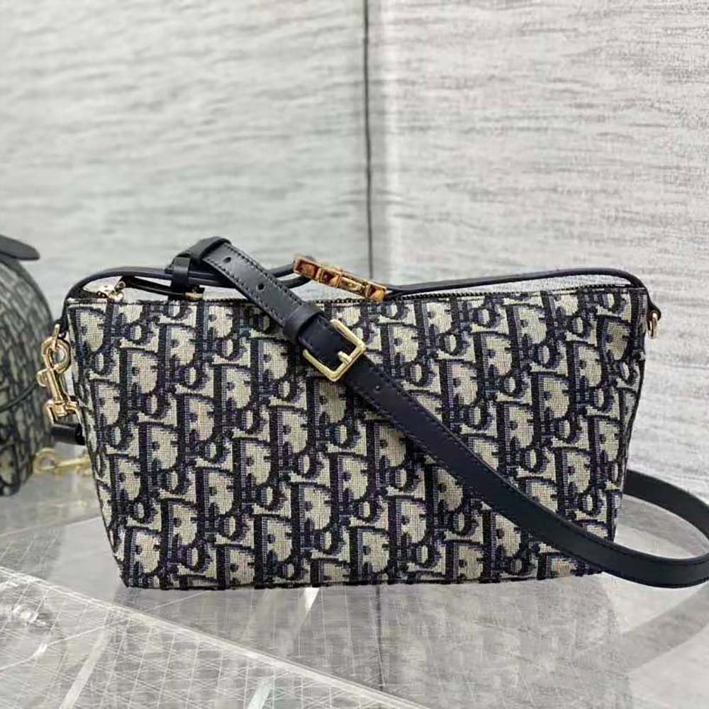 Close-up detail of blue Dior Oblique jacquard pattern on Diortravel Nomad Pouch