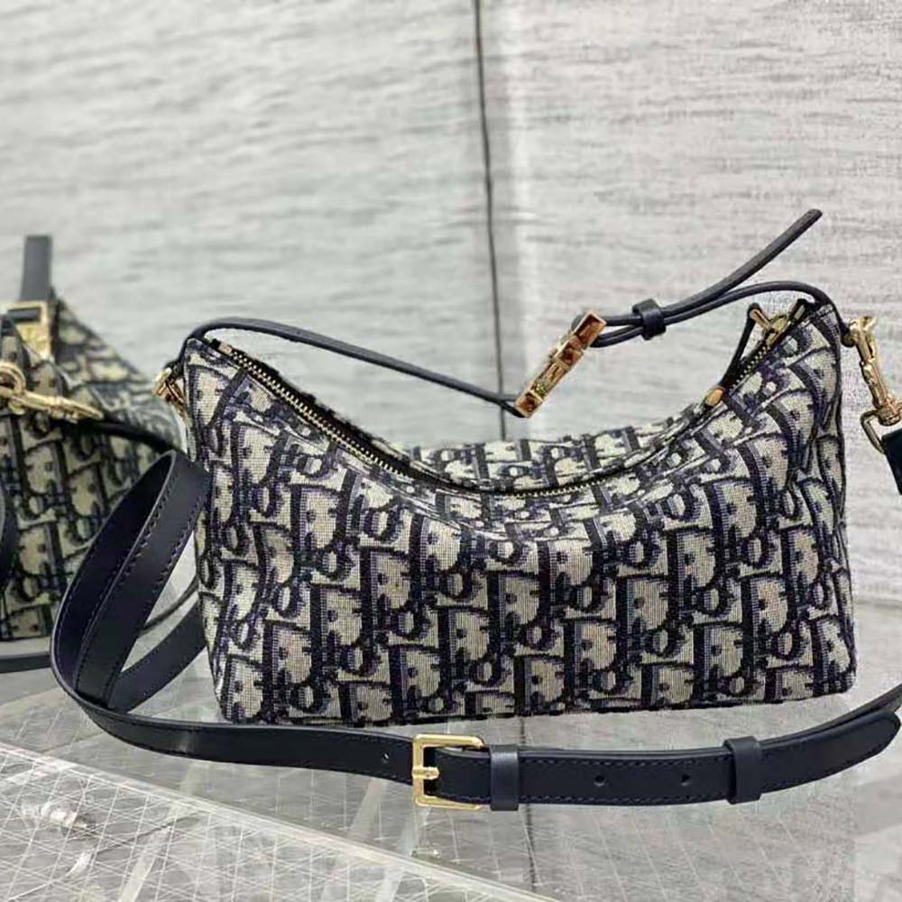 Top angle showing gold-tone zip closure on Dior Women Medium Diortravel Nomad Pouch