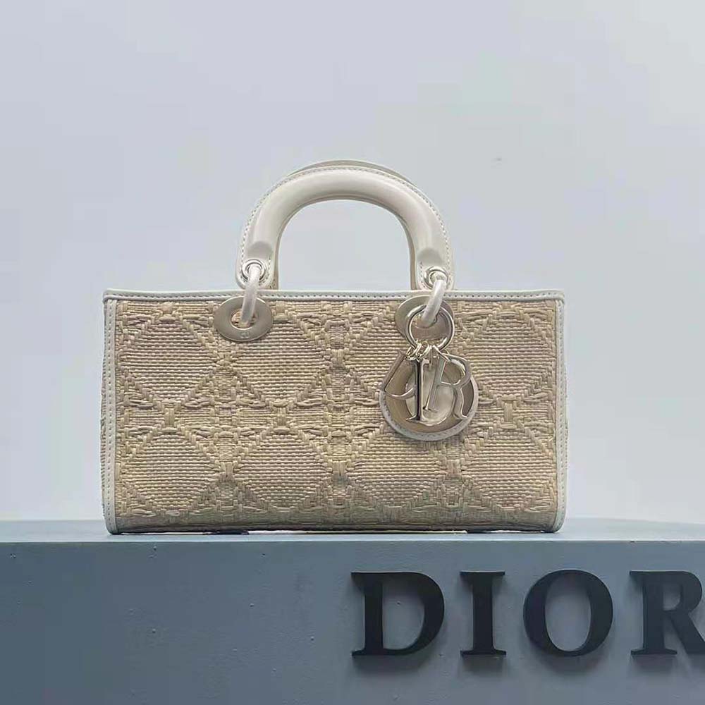 Close-up of gold-tone closure and woven raffia detail on Dior bag