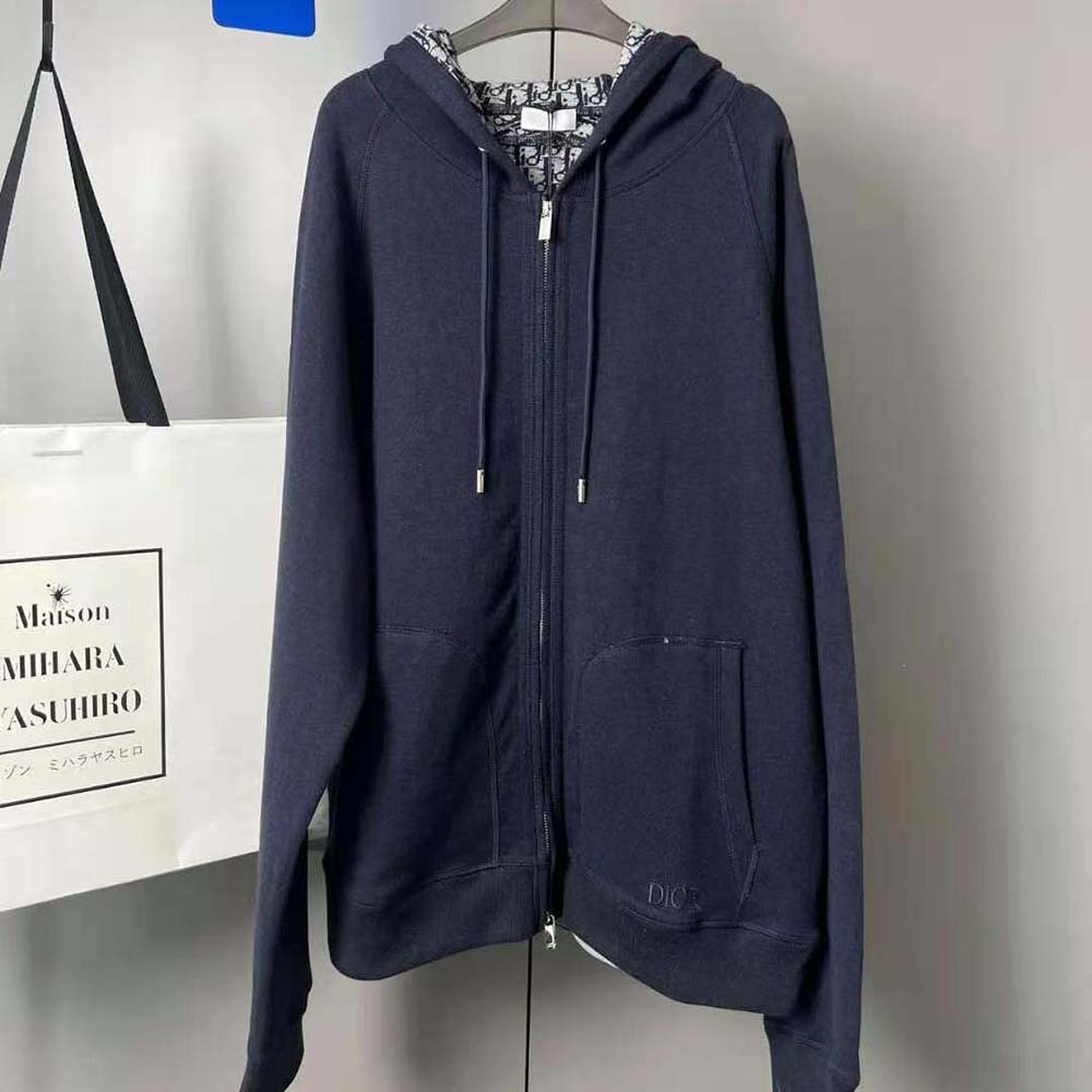 Close-up of zipper and Dior logo hardware on the navy blue jacket
