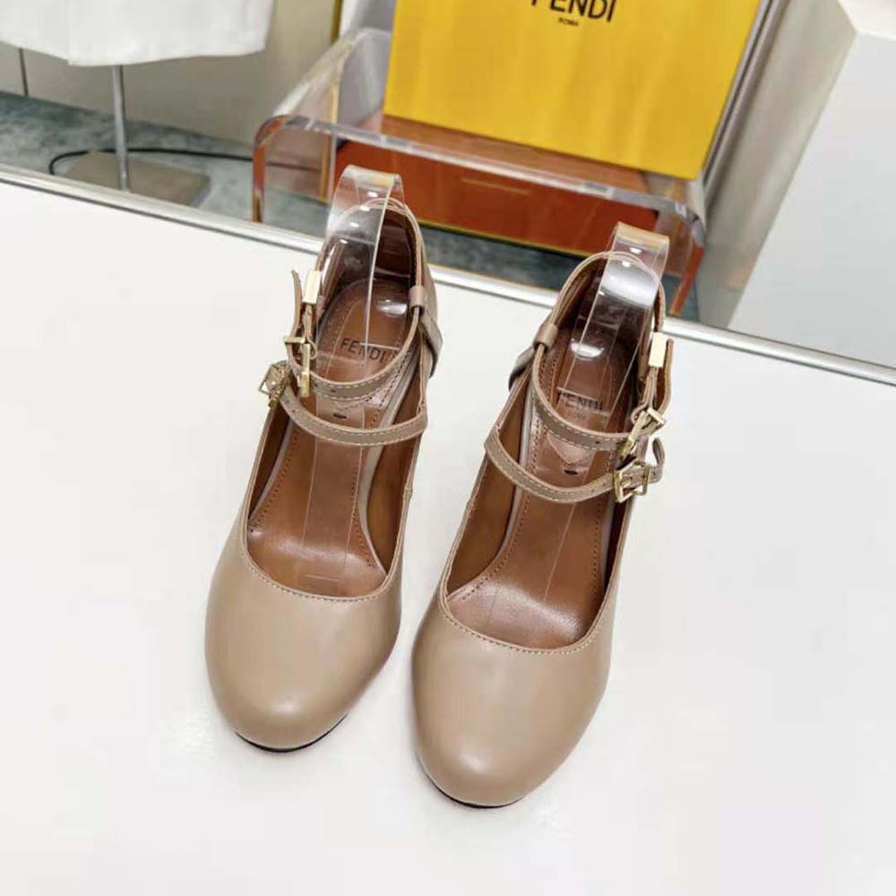 Close-up on gold Fendi logo hardware on Delfina Dove Gray court shoes