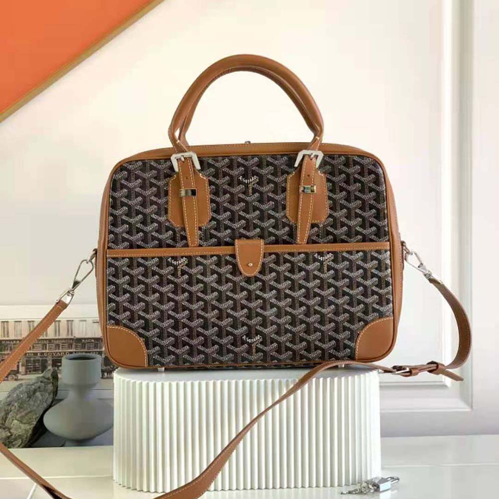 Close-up detail of brown leather trim and gold hardware on Goyard document case