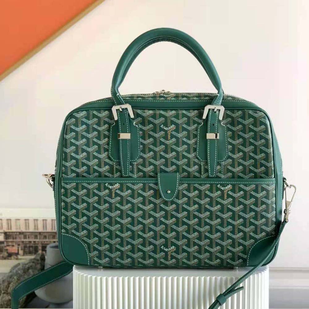 Close-up of polished brass zipper and green Goyardine canvas detail