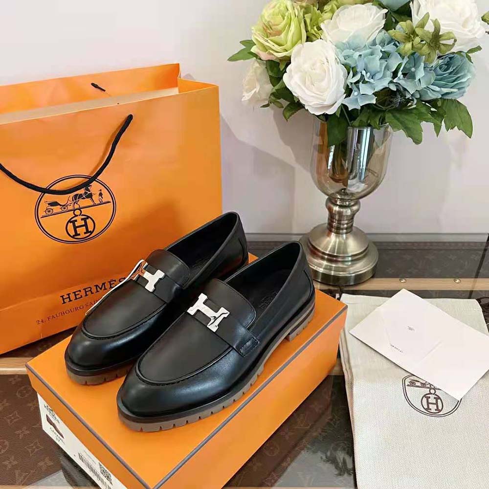 Close-up of Hermes logo hardware on blue Faubourg Loafer