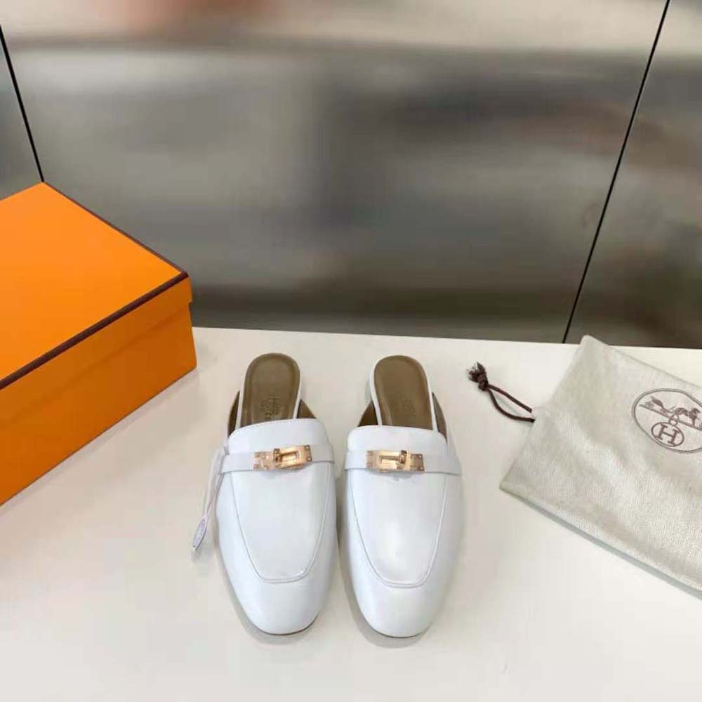 Close-up of smooth white calfskin and Hermes logo embossing on mule