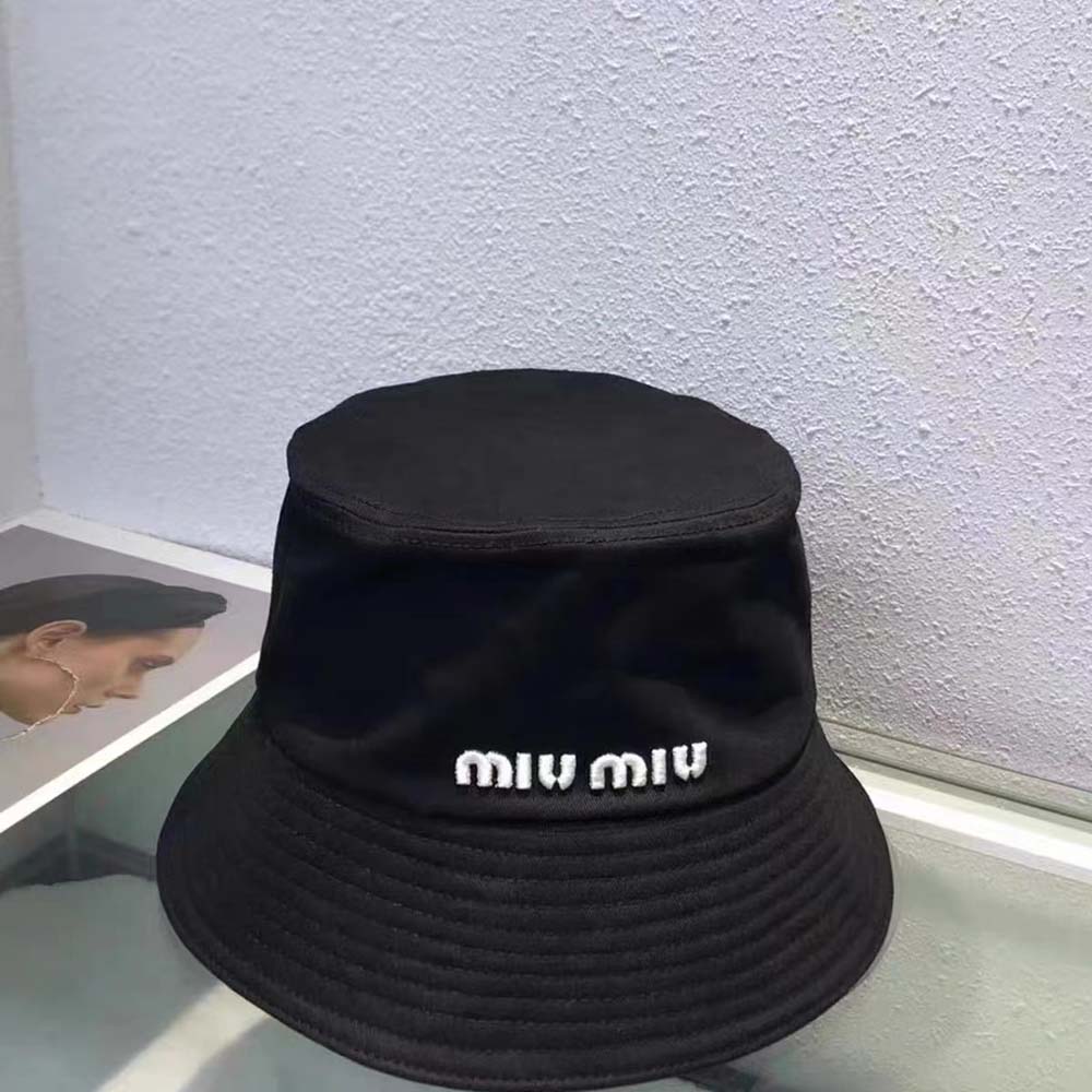 Close-up of embroidered Miu Miu logo on black bucket hat fabric