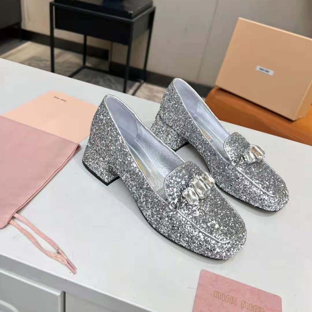 Top angle showing silver glitter fabric and slip-on design of Miu Miu loafers