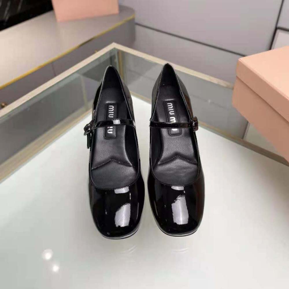 Close-up detail of metal lettering logo on patent leather pump vamp