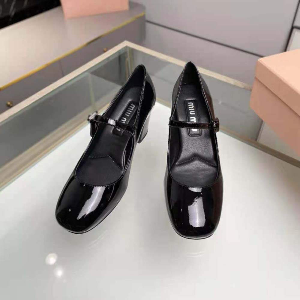 Rear view showcasing heel height and glossy finish of Miu Miu patent pumps