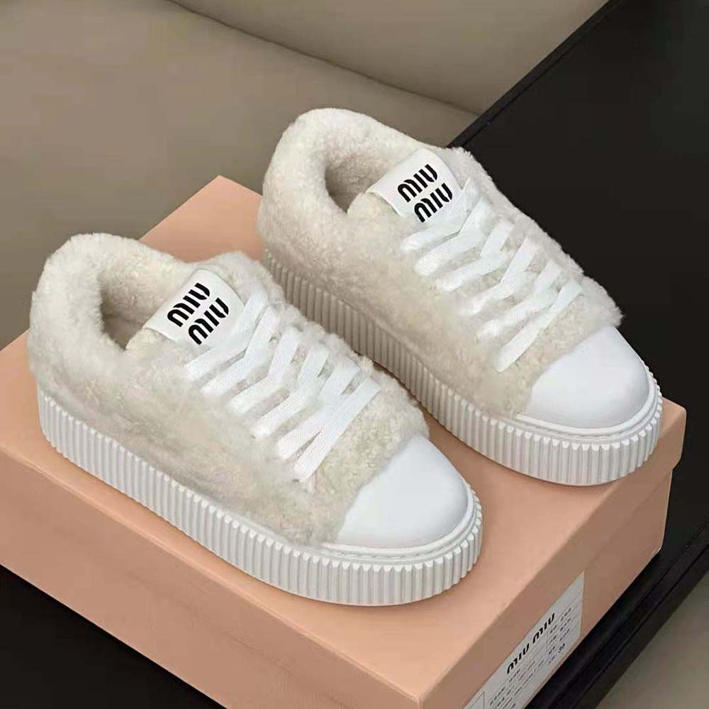 Close-up detail of shearling texture and Miu Miu logo on sneakers