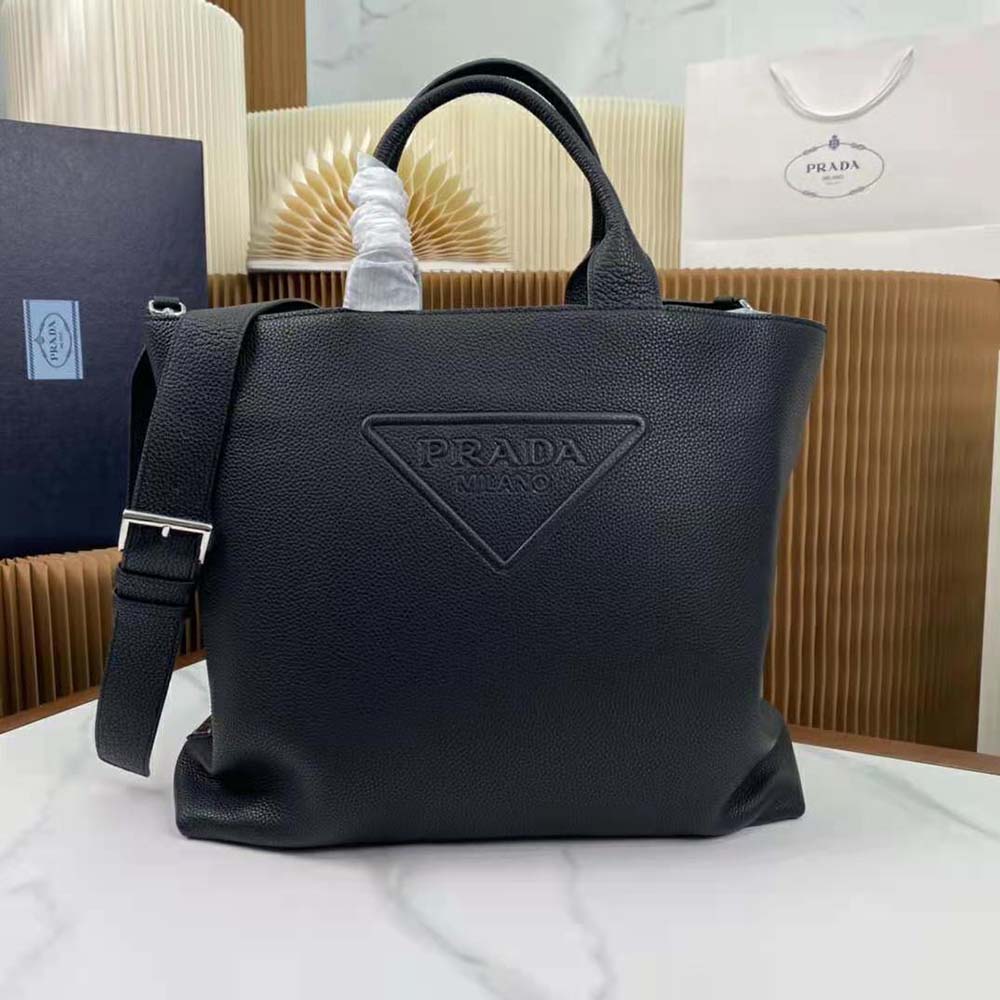 Close-up of enameled metal triangle logo on Prada Men Leather Tote black leather