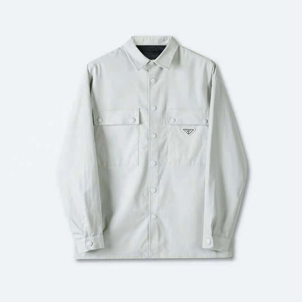 Close-up of button and Prada metal logo on white corduroy shirt