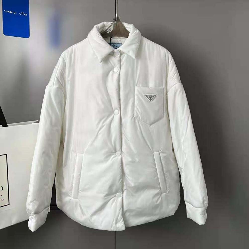 Close-up on Prada logo plaque and zip detail of white padded jacket