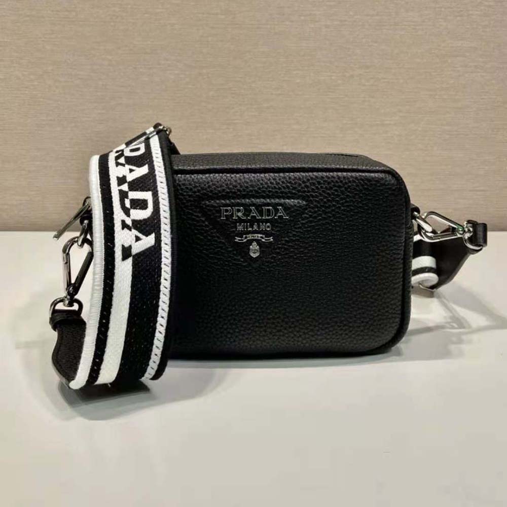 Close-up of silver-tone Prada logo hardware on black leather bag