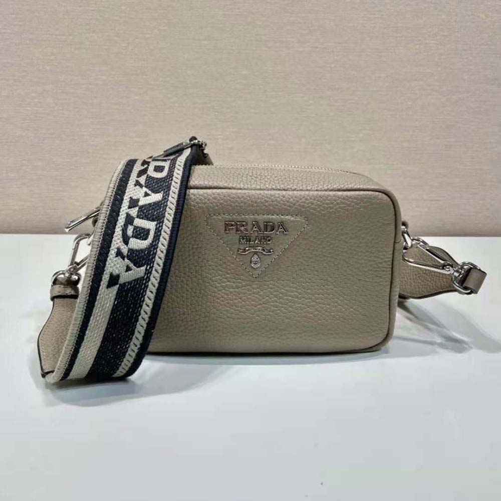 Close-up of gold-tone hardware and Prada logo on small leather bag