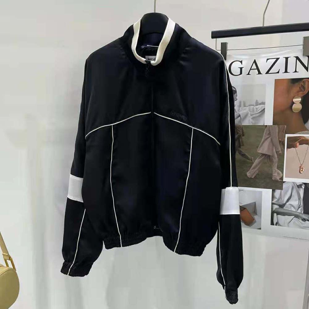Close-up of YSL logo hardware on black satin crepe jacket
