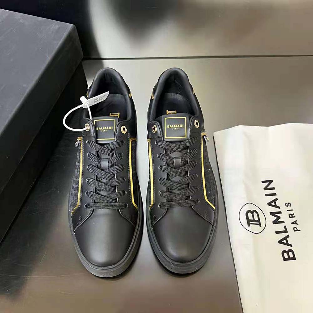 Close-up of Balmain monogram detail on black leather trainer