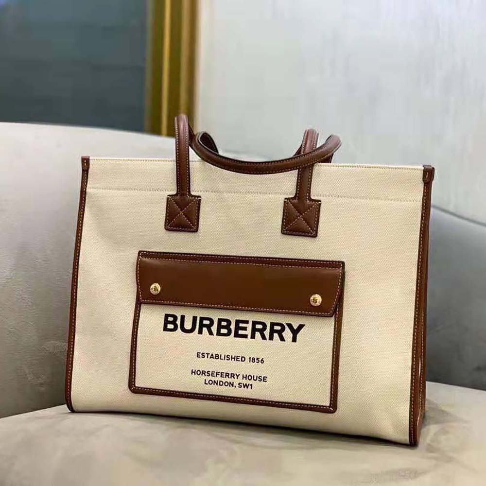 Side angle showing structured silhouette of Burberry Women Medium Freya Tote-Beige