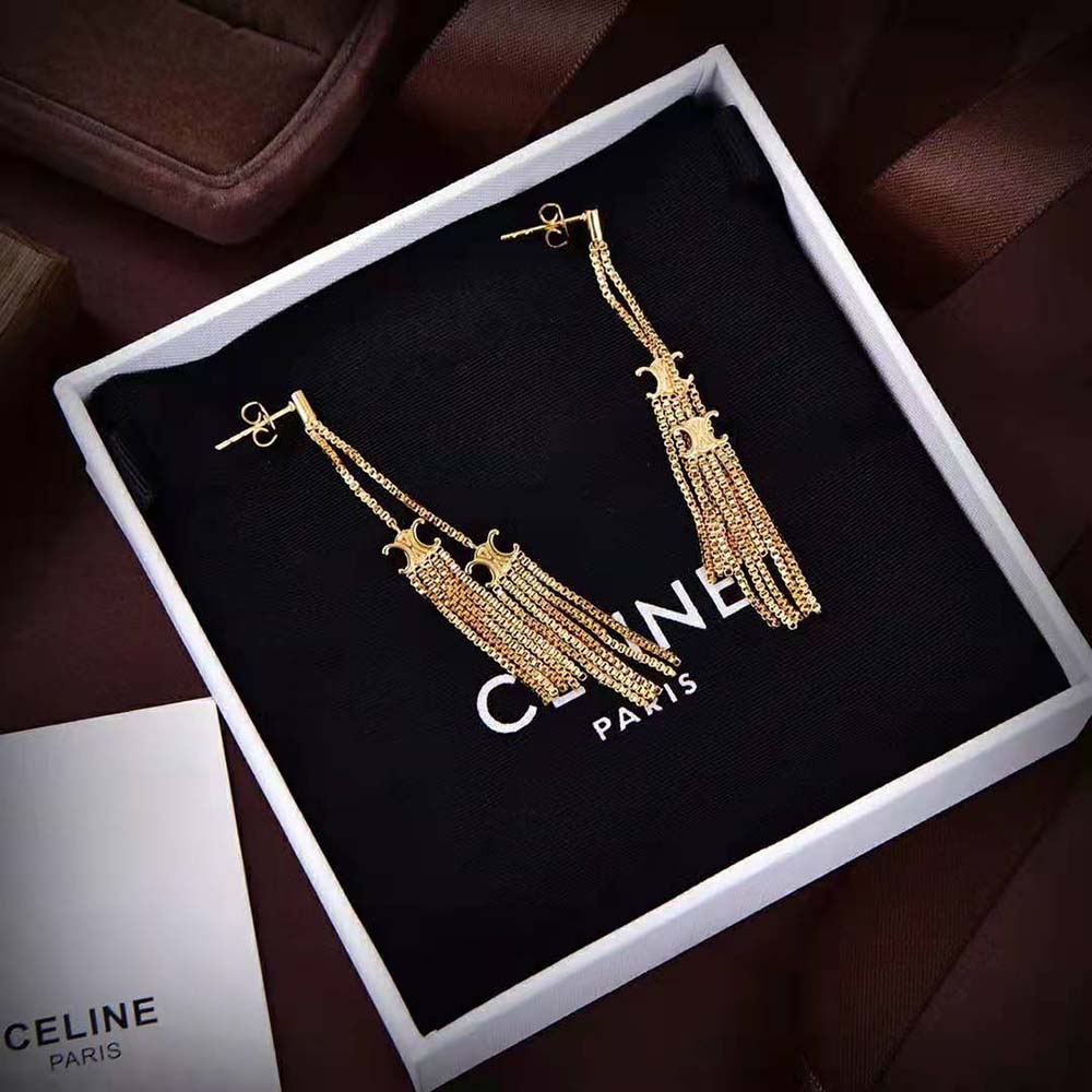 Close-up detail of pompon and Triomphe emblem on Celine earrings