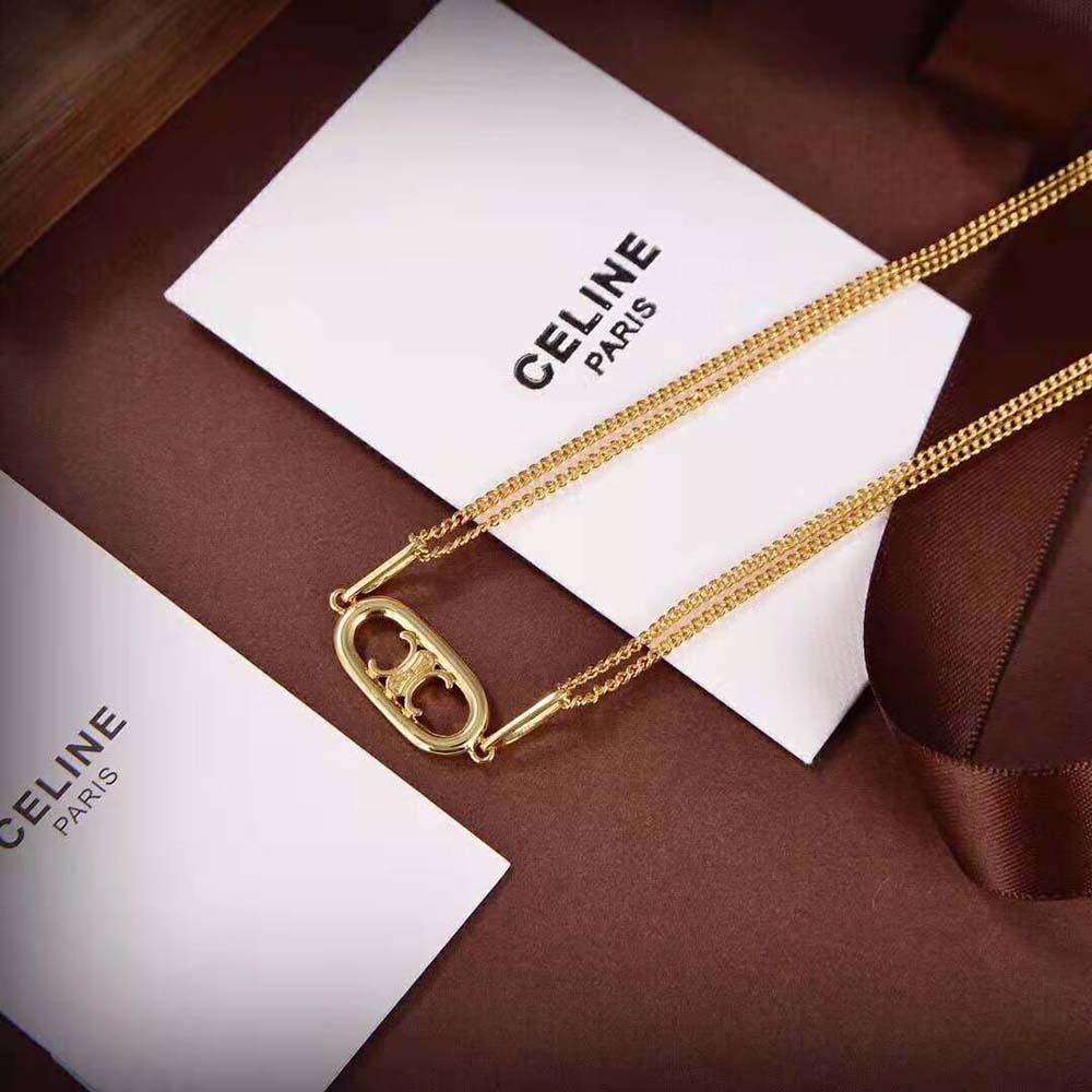 Close-up of YSL Triomphe pendant detail on Gold Brass necklace