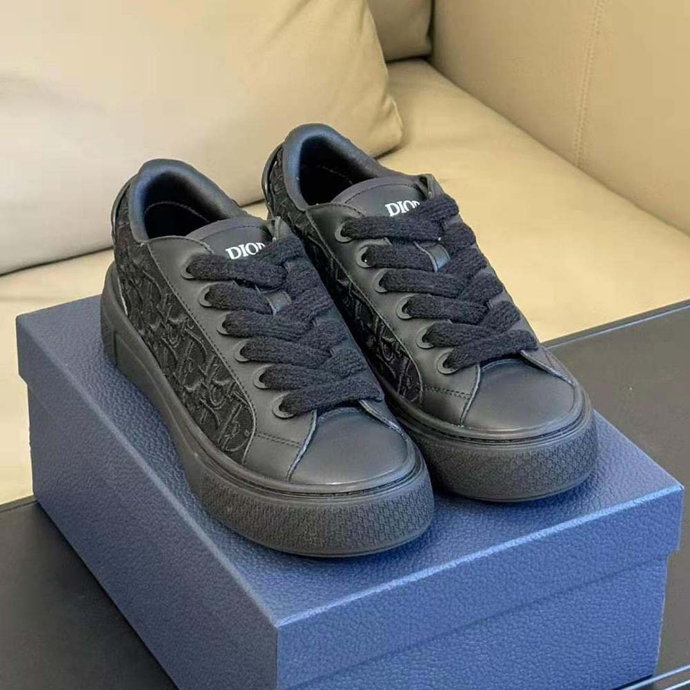 Close-up of silver Dior hardware on black smooth calfskin sneaker
