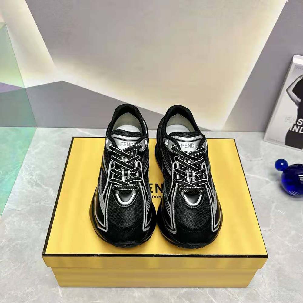 Close-up detail of Fendi logo hardware on black sneakers