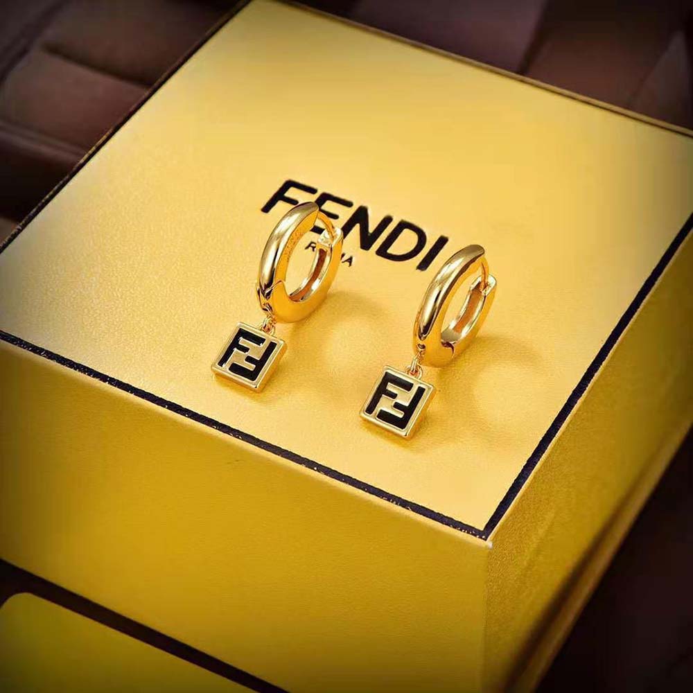 Close-up of gold-colored metal and black enamel on Fendi earrings