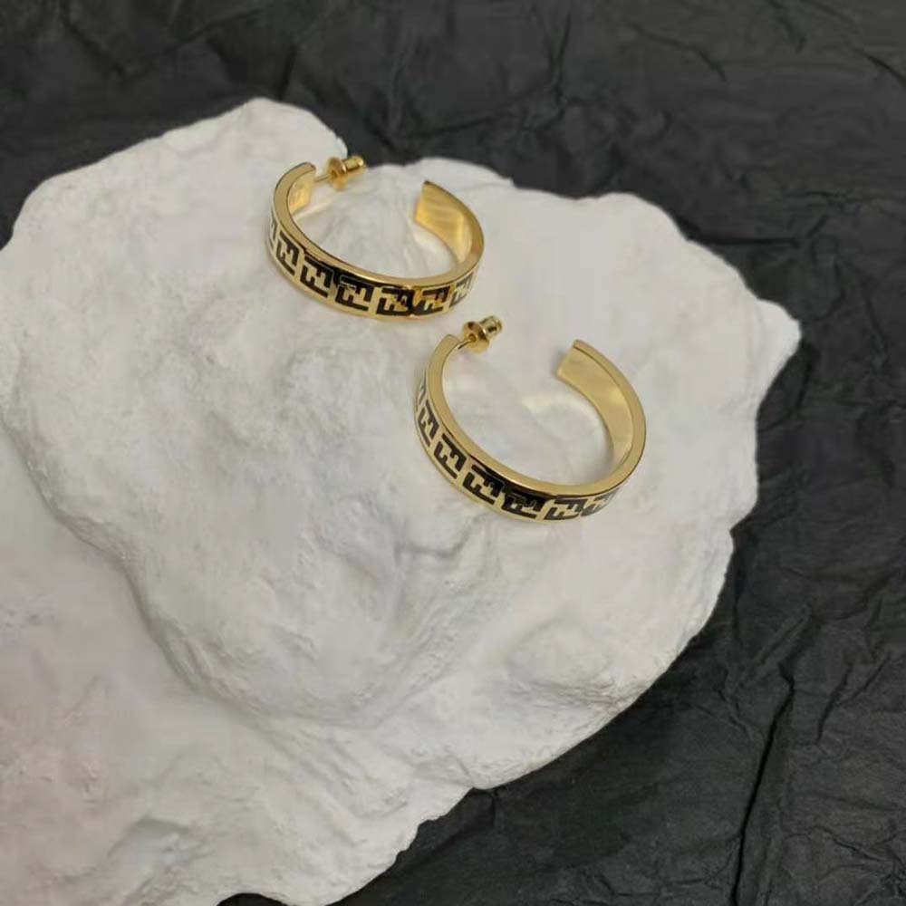 Detail shot of signature Fendi logo hardware on gold-coloured earrings