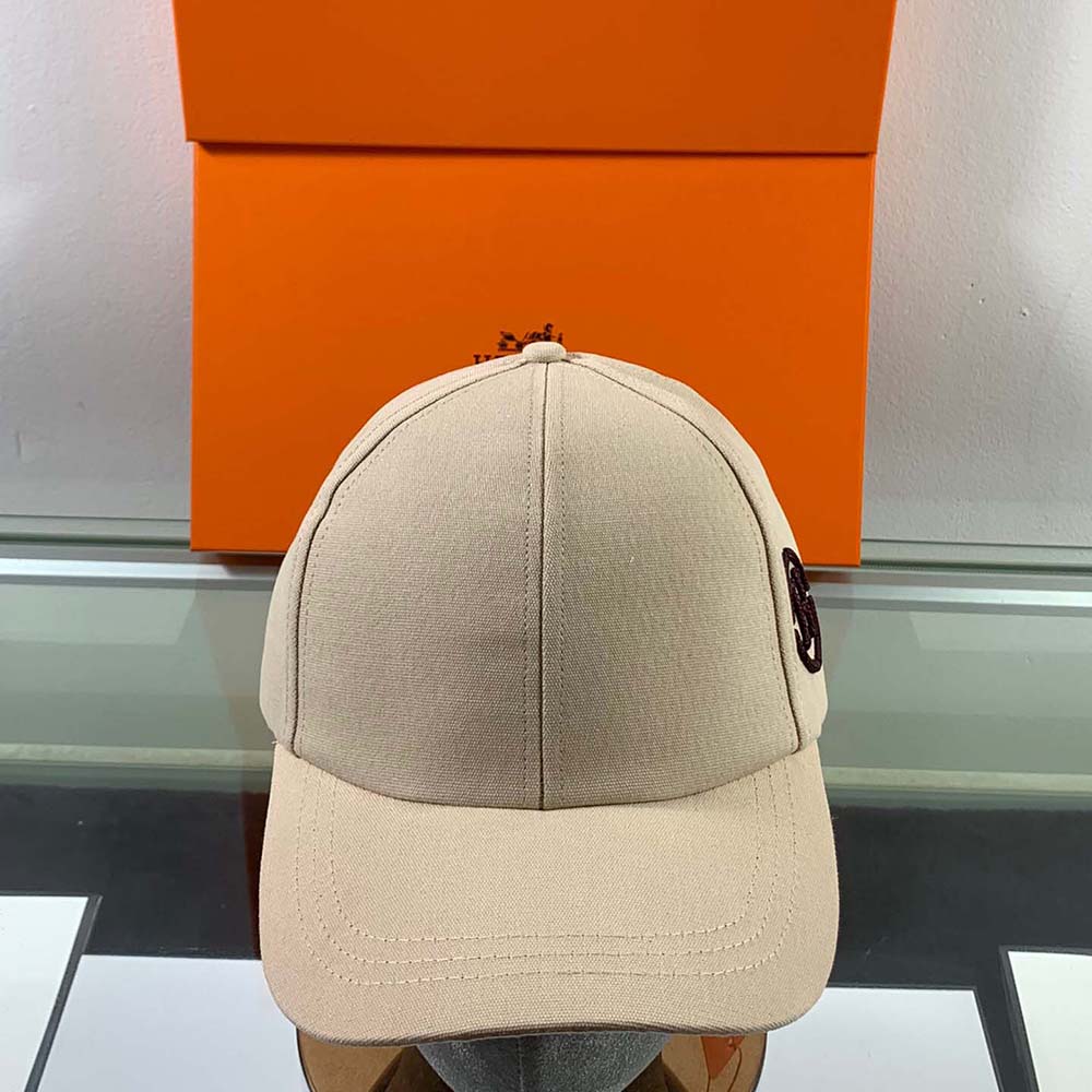 Close-up of metal H Circle emblem on Hermes Men Miles H Circle Cap