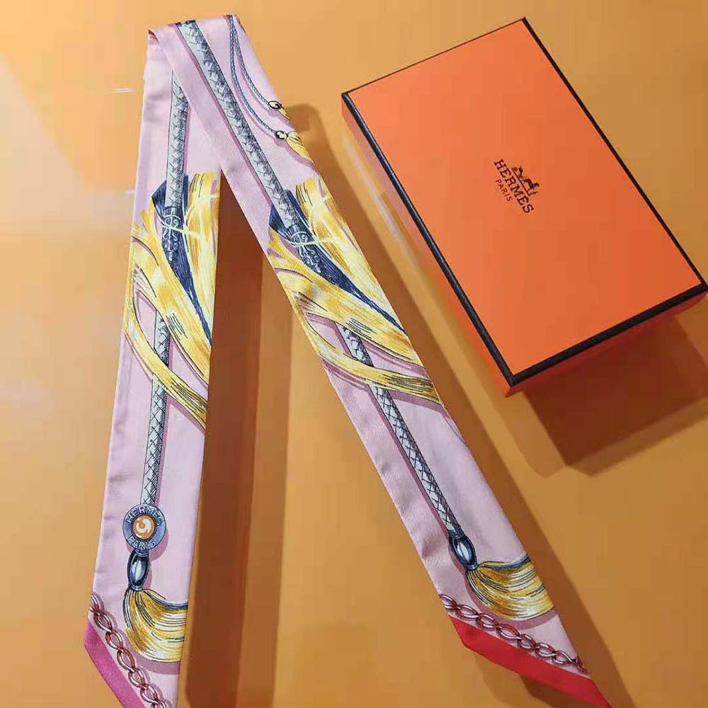 Side view of Hermes Women Cavalcades Twilly-Pink wrapped on wrist